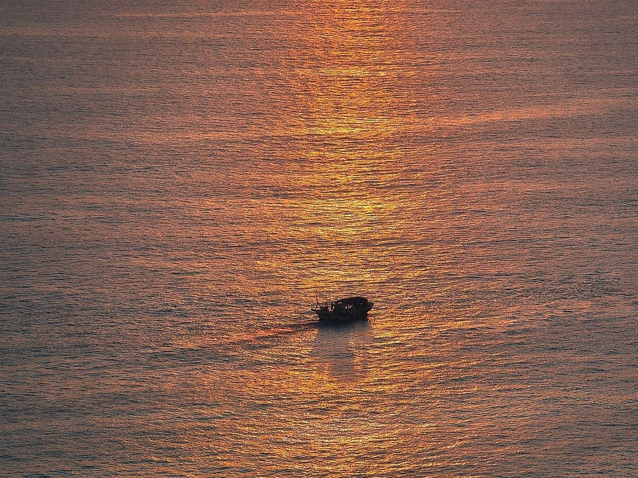 Pescadores em rio de correnteza moderada durante pôr do sol